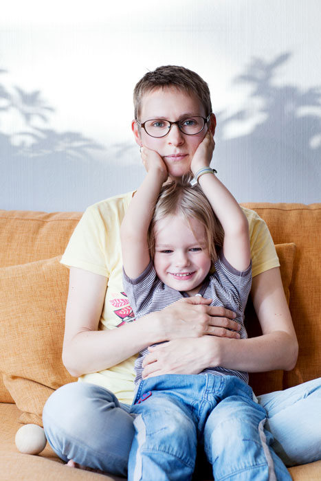 En kvinna och en liten flicka sitter i en soffa